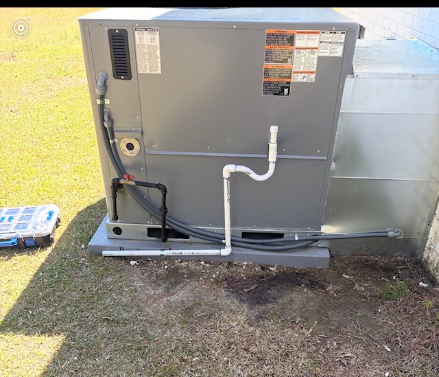 Rear view of a package HVAC unit during a maintenance visit